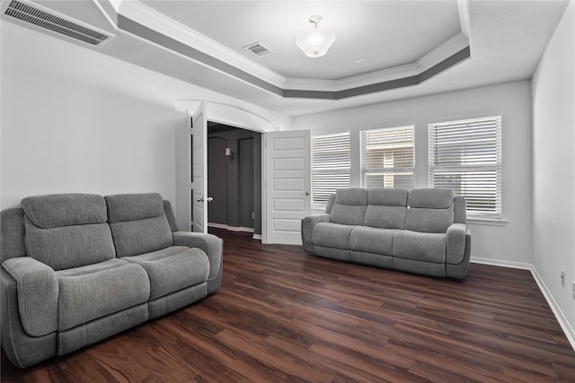 living room with crown molding, a raised ceiling, and dark hardwood / wood-style flooring