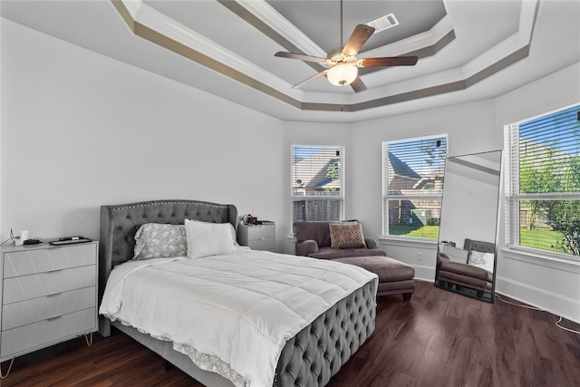 bedroom with ceiling fan, a tray ceiling, dark hardwood / wood-style flooring, and crown molding