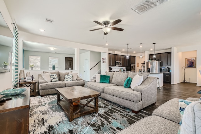 living room featuring ceiling fan and dark hardwood / wood-style flooring