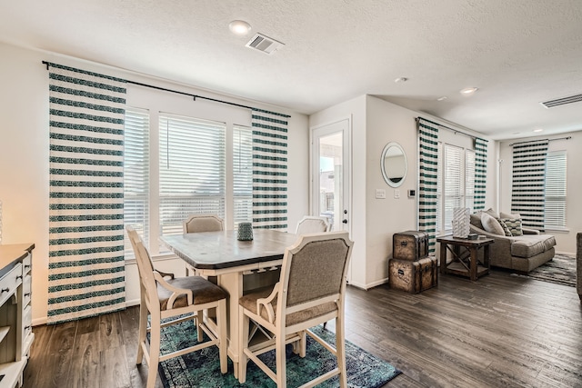 dining area featuring a textured ceiling and dark hardwood / wood-style flooring