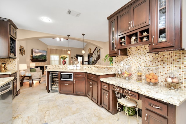 kitchen with decorative backsplash, kitchen peninsula, wine cooler, decorative light fixtures, and appliances with stainless steel finishes