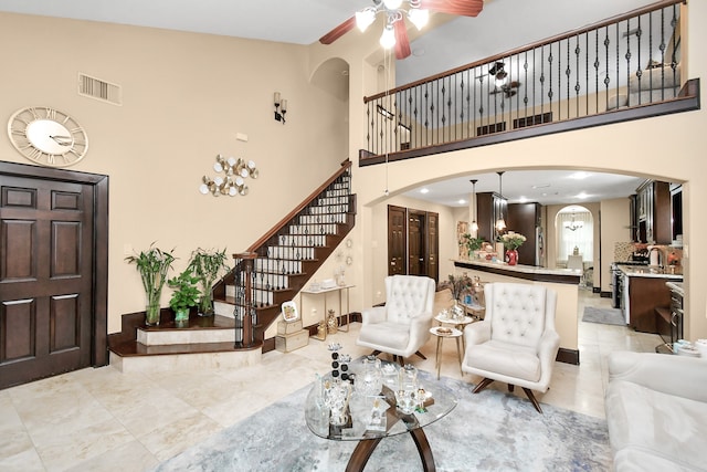 living room featuring a towering ceiling and ceiling fan