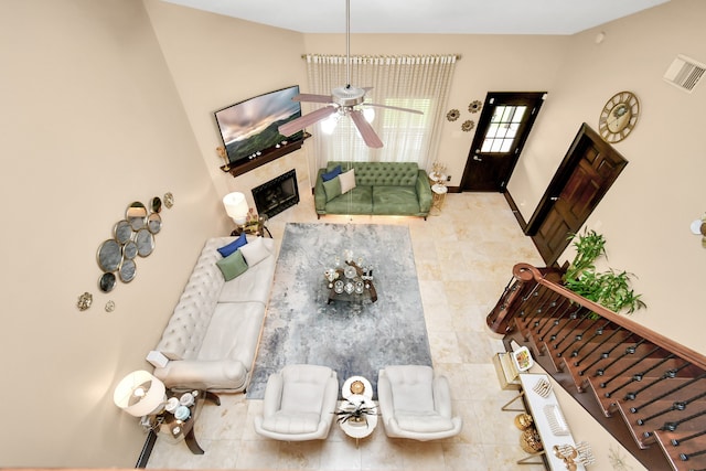 living room with a fireplace and ceiling fan