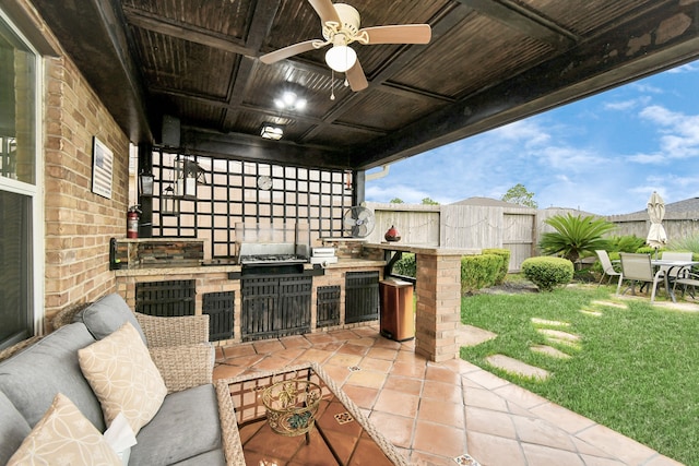 view of patio / terrace featuring ceiling fan, a grill, and exterior kitchen