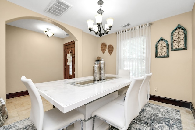 tiled dining room featuring a notable chandelier