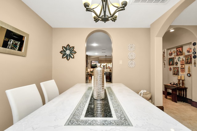 dining area with carpet and an inviting chandelier