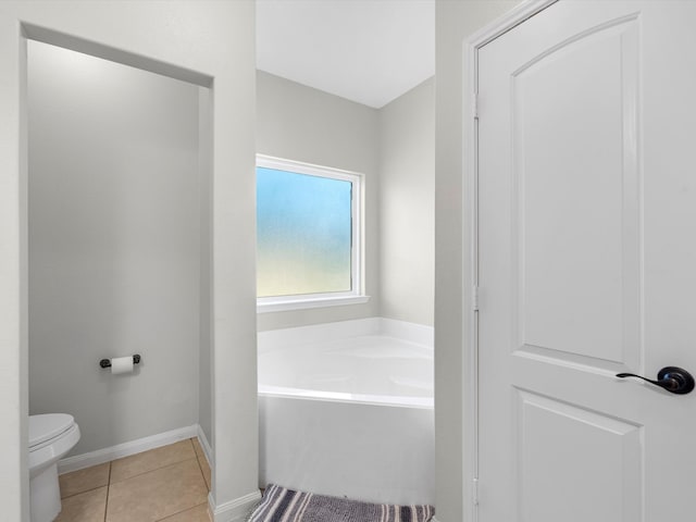 bathroom with a bathtub, toilet, and tile patterned floors