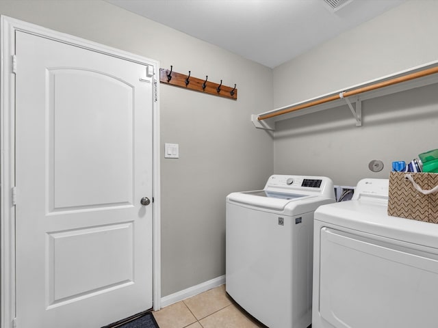 laundry room featuring washer and dryer and light tile patterned flooring