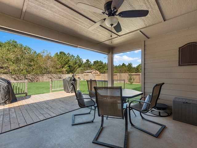 view of patio with area for grilling, a wooden deck, and ceiling fan