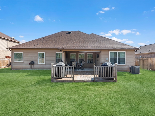 back of house featuring a lawn and central AC unit