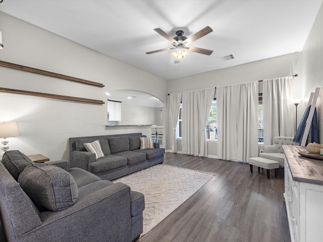 living room with dark wood-type flooring and ceiling fan