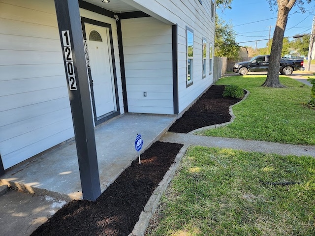 view of exterior entry with a yard