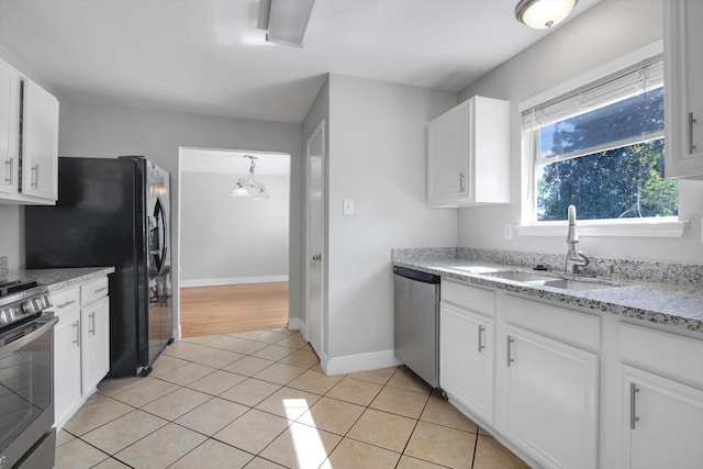 kitchen featuring white cabinetry, sink, light tile patterned floors, and stainless steel appliances