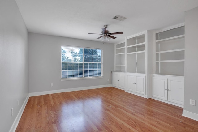 spare room with ceiling fan, light hardwood / wood-style flooring, and built in features