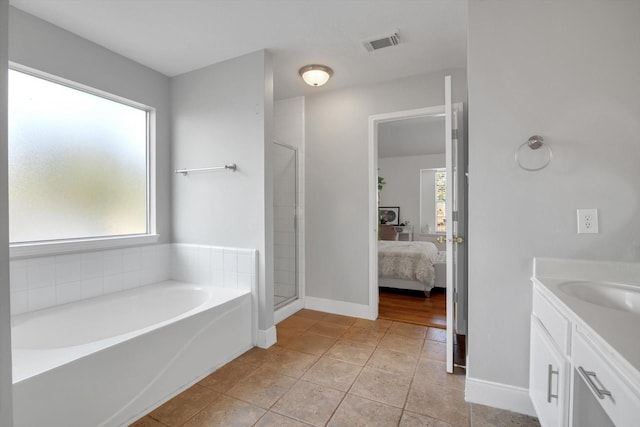 bathroom with vanity, tile patterned flooring, and plus walk in shower