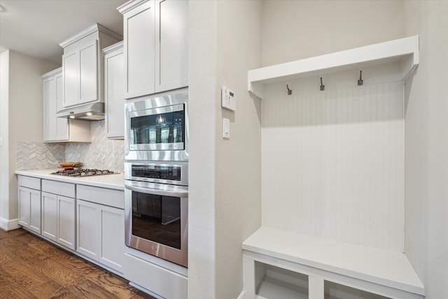 kitchen featuring stainless steel appliances, white cabinetry, tasteful backsplash, and dark hardwood / wood-style flooring