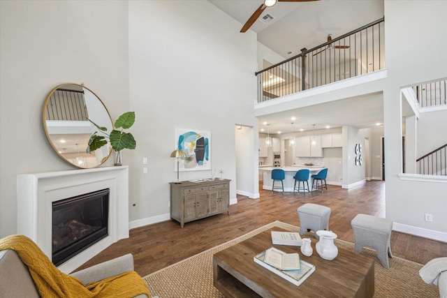 living room with dark wood-type flooring and a high ceiling