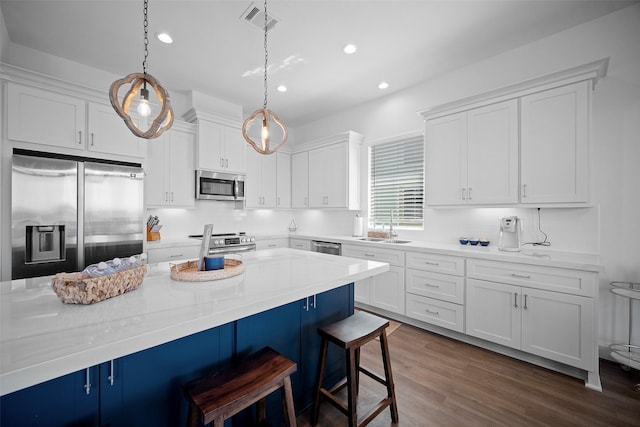 22831 Cuadro St, Galveston, TX 77554 - kitchen with stainless steel appliances, a kitchen bar, white cabinets, recessed lighting, and a sink