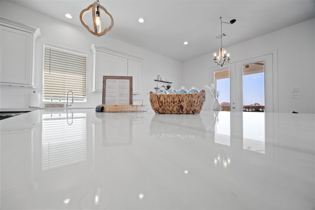 kitchen featuring french doors, white cabinetry, pendant lighting, and a healthy amount of sunlight