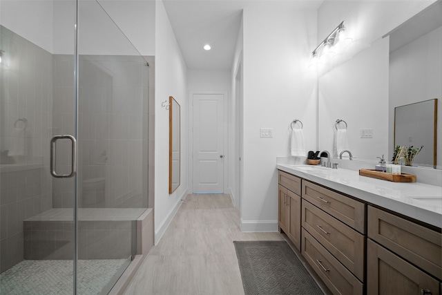 bathroom featuring vanity, wood-type flooring, and a shower with shower door