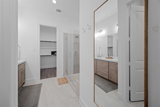 bathroom featuring vanity, hardwood / wood-style flooring, and a shower with shower door