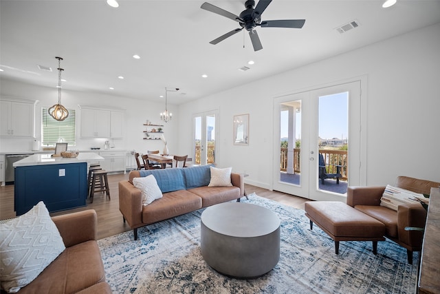 living room featuring french doors, ceiling fan, and light hardwood / wood-style flooring