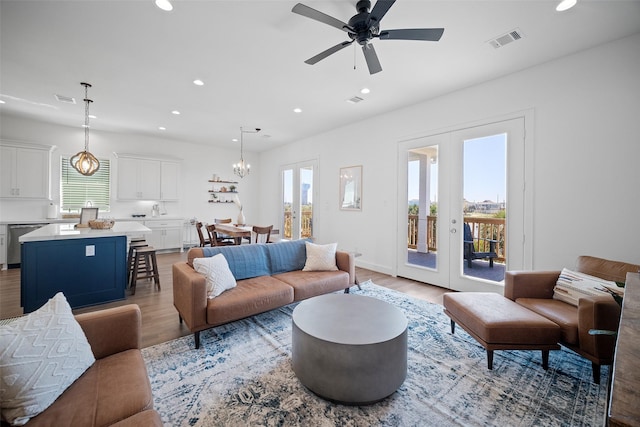 22831 Cuadro St, Galveston, TX 77554 - living area with light wood-type flooring, recessed lighting, french doors, a ceiling fan, and a chandelier