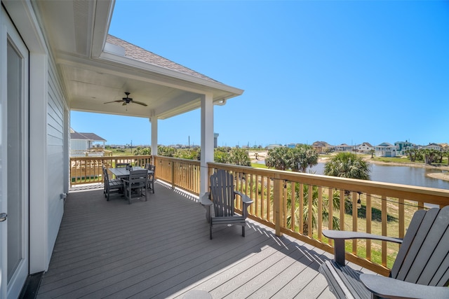 wooden deck with a water view and ceiling fan