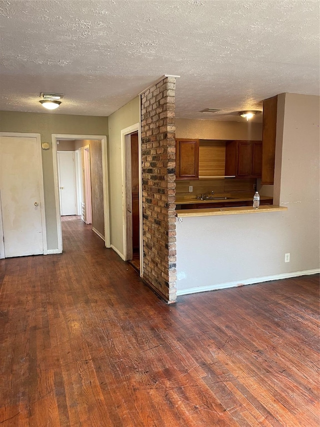 kitchen with a textured ceiling and dark hardwood / wood-style floors