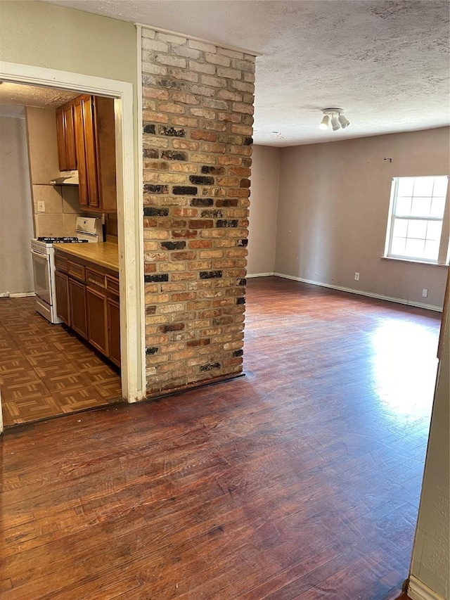 spare room with dark hardwood / wood-style flooring and a textured ceiling