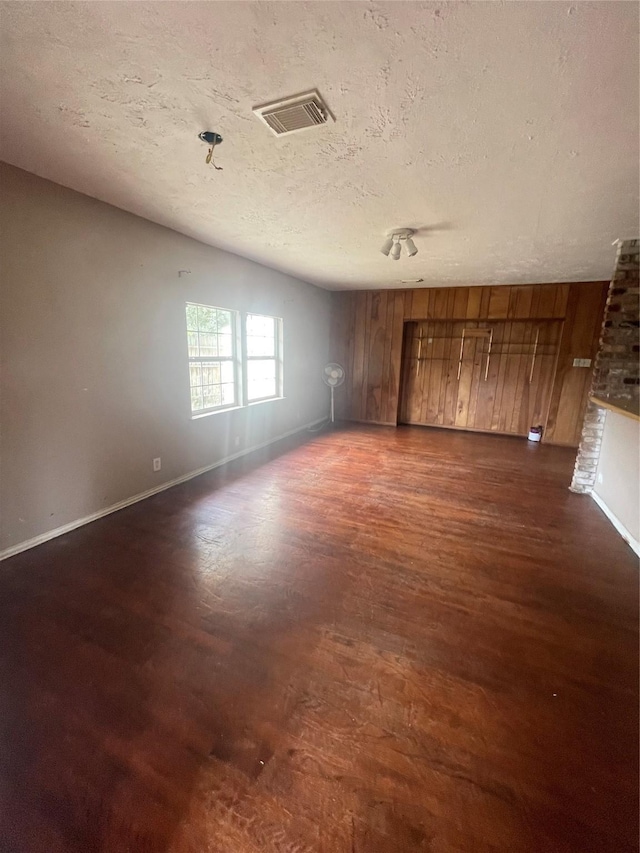 empty room featuring dark hardwood / wood-style flooring and a textured ceiling