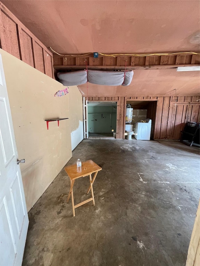 garage featuring wooden walls and gas water heater