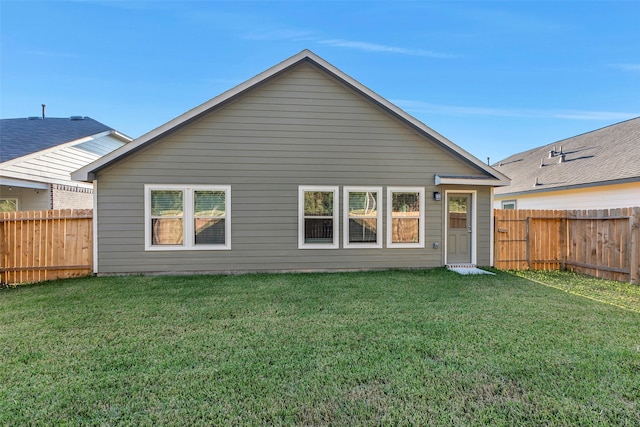 rear view of house featuring a lawn