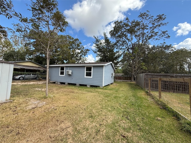 rear view of house with a wall mounted AC and a lawn