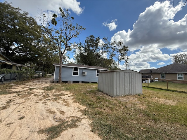 back of house with a shed and a yard