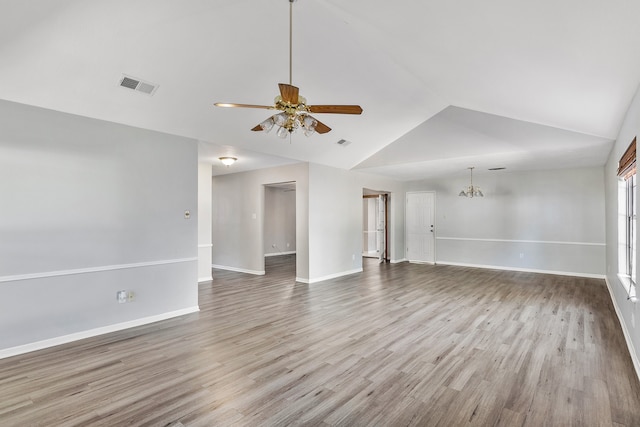 interior space with light hardwood / wood-style floors, vaulted ceiling, and ceiling fan with notable chandelier