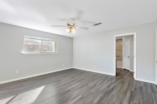 empty room featuring dark wood-type flooring, a textured ceiling, and ceiling fan