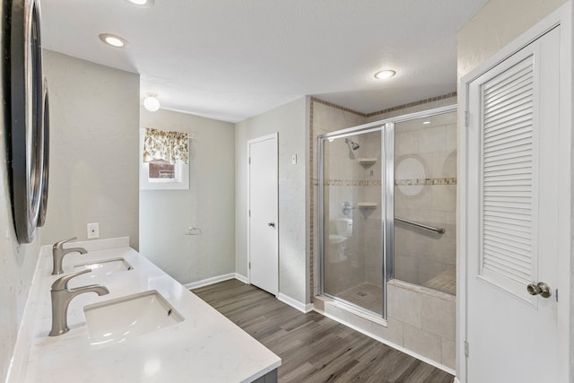 bathroom with vanity, a textured ceiling, hardwood / wood-style flooring, and walk in shower