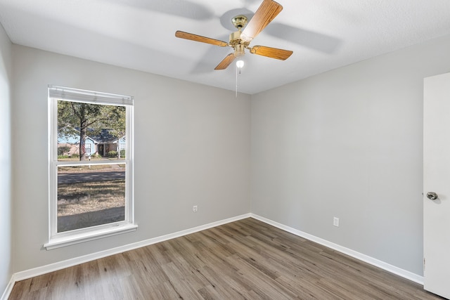 empty room with a textured ceiling, wood-type flooring, and ceiling fan