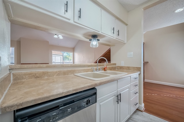 kitchen with white cabinets, a textured ceiling, stainless steel dishwasher, light wood-type flooring, and sink