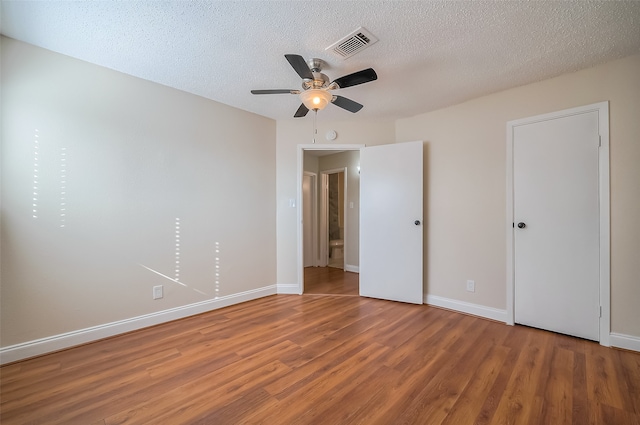 unfurnished bedroom featuring ceiling fan, a textured ceiling, and hardwood / wood-style floors