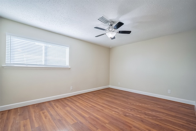 empty room with a textured ceiling, hardwood / wood-style flooring, and ceiling fan