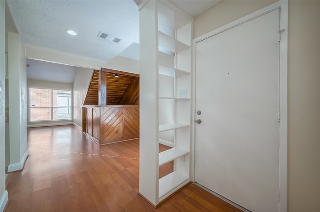 hallway featuring hardwood / wood-style flooring and a textured ceiling