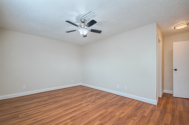 spare room with a textured ceiling, hardwood / wood-style flooring, and ceiling fan