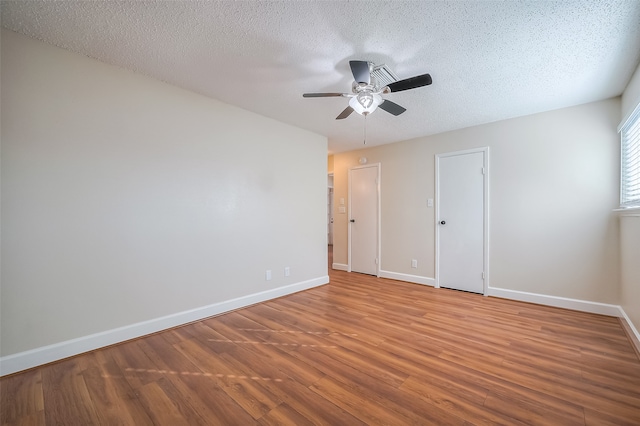 spare room with ceiling fan, a textured ceiling, and hardwood / wood-style floors