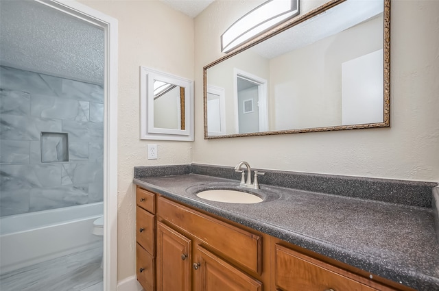 full bathroom featuring vanity, toilet, a textured ceiling, and shower / washtub combination