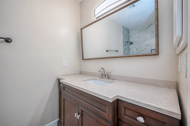 bathroom featuring vanity, a textured ceiling, and walk in shower