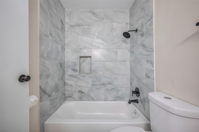 bathroom featuring tiled shower / bath combo, a textured ceiling, and toilet