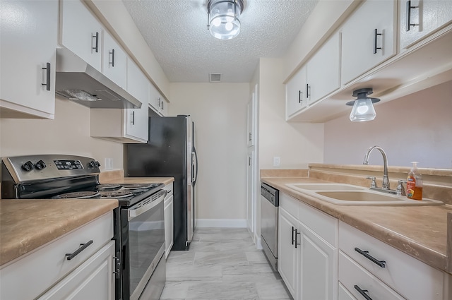 kitchen featuring appliances with stainless steel finishes, white cabinets, sink, and a textured ceiling