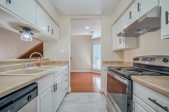 kitchen with sink, appliances with stainless steel finishes, a textured ceiling, and white cabinetry